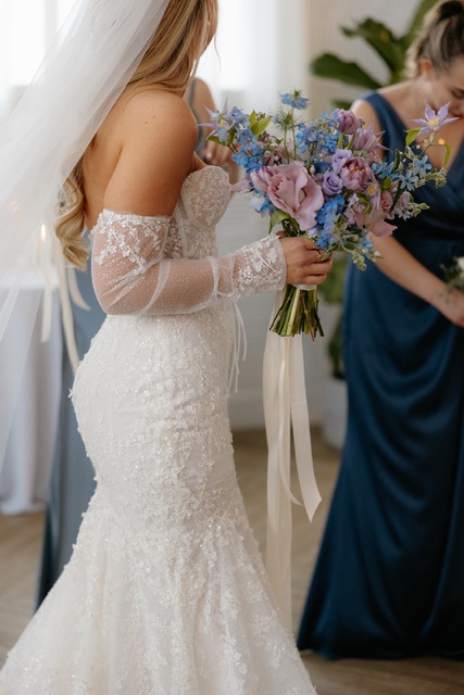 A bride holding her bouquet before walking down the aisle.